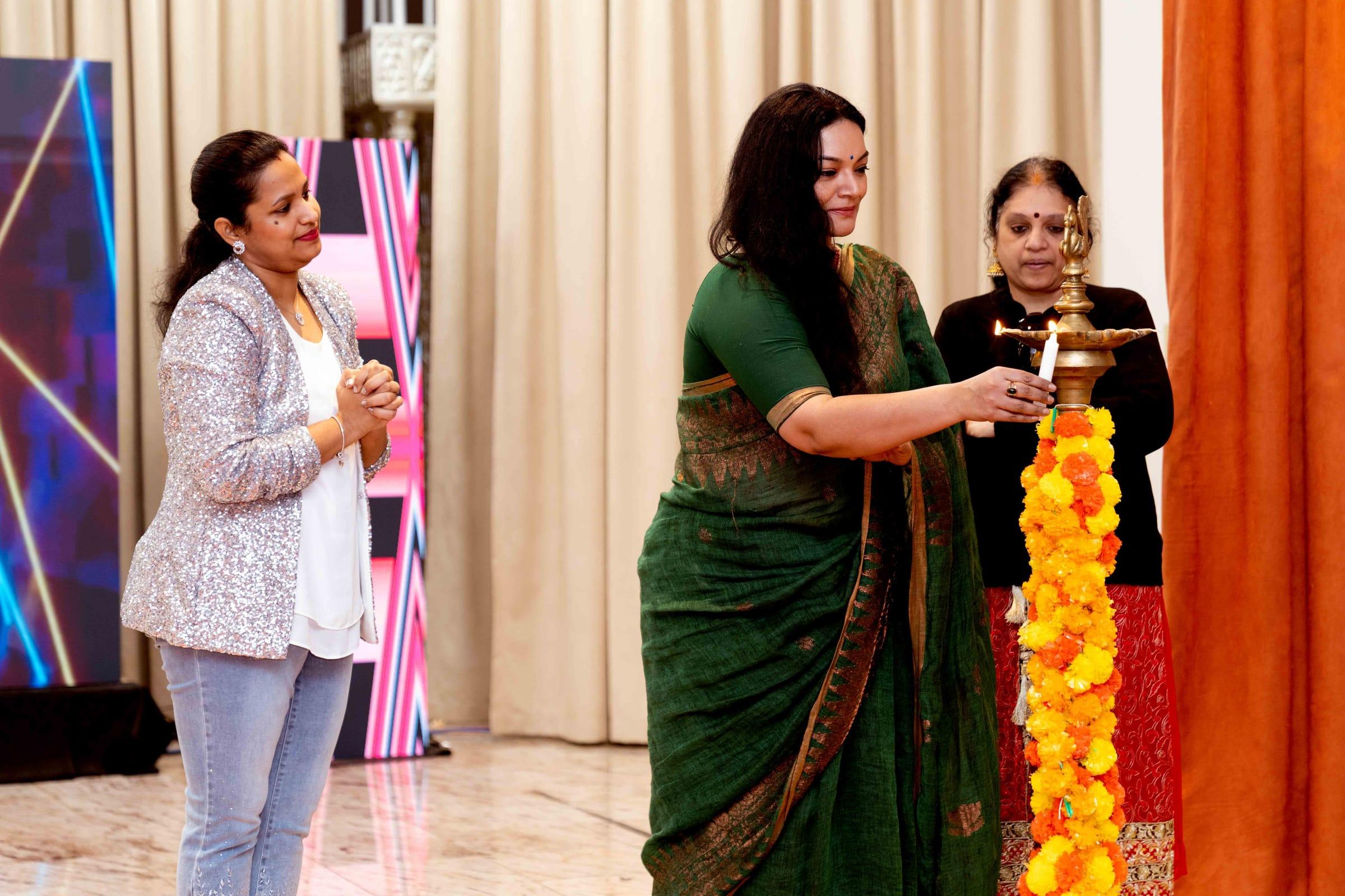 Guests light the traditional lamp to open a cultural event