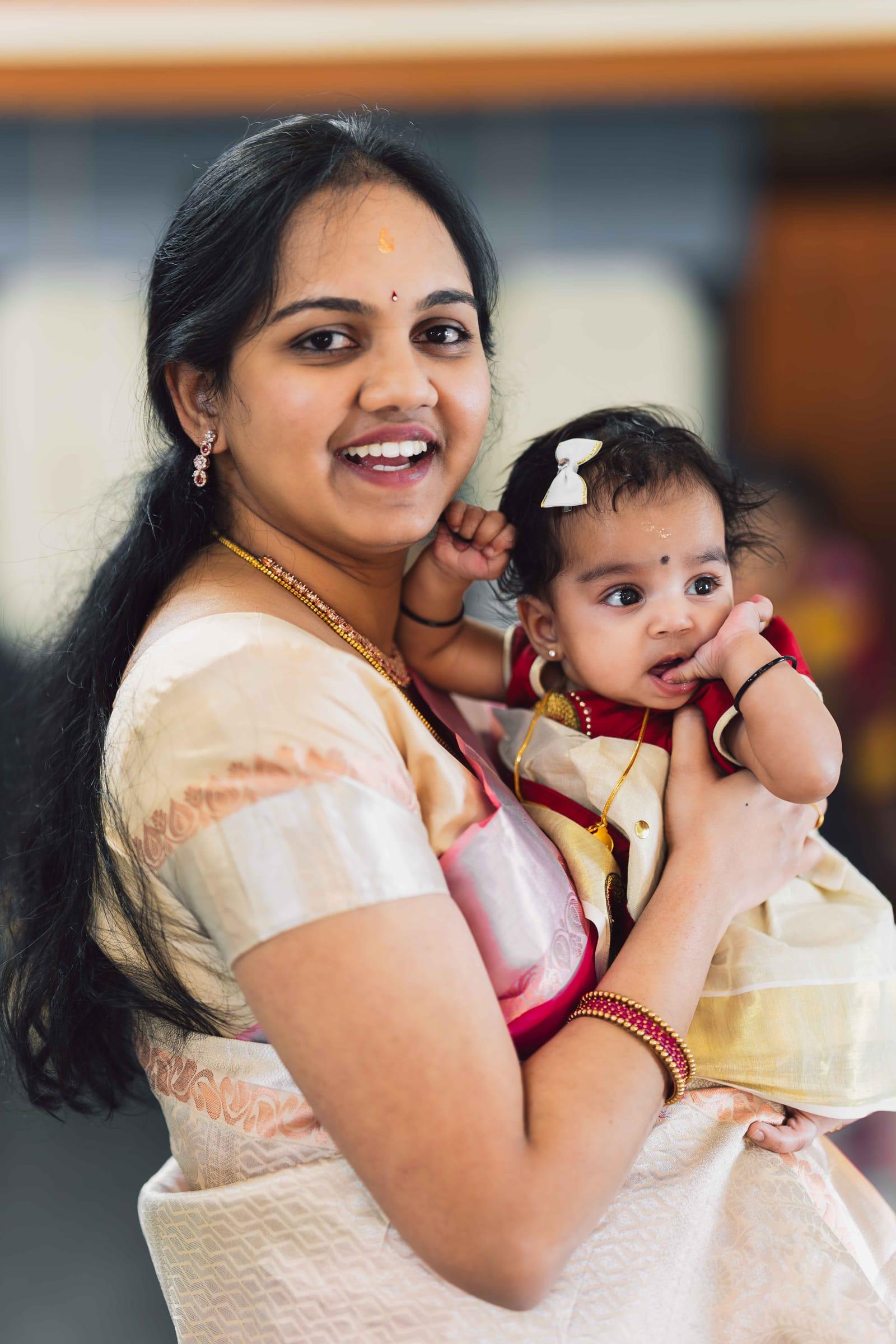 Mother holding her baby daughter in a traditional saree