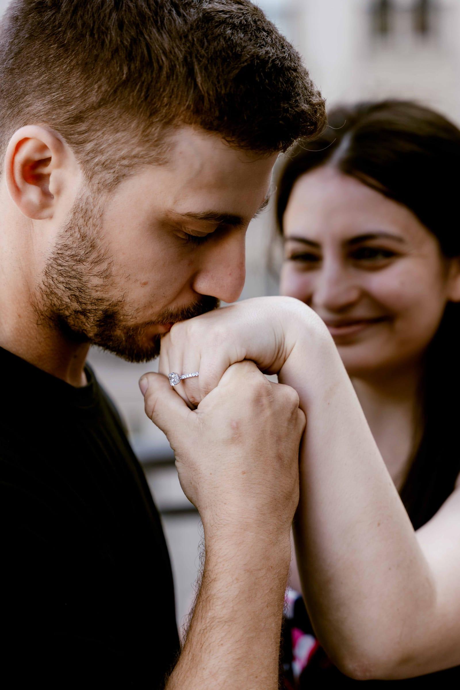 Fiancé kisses her hand showing the engagement ring