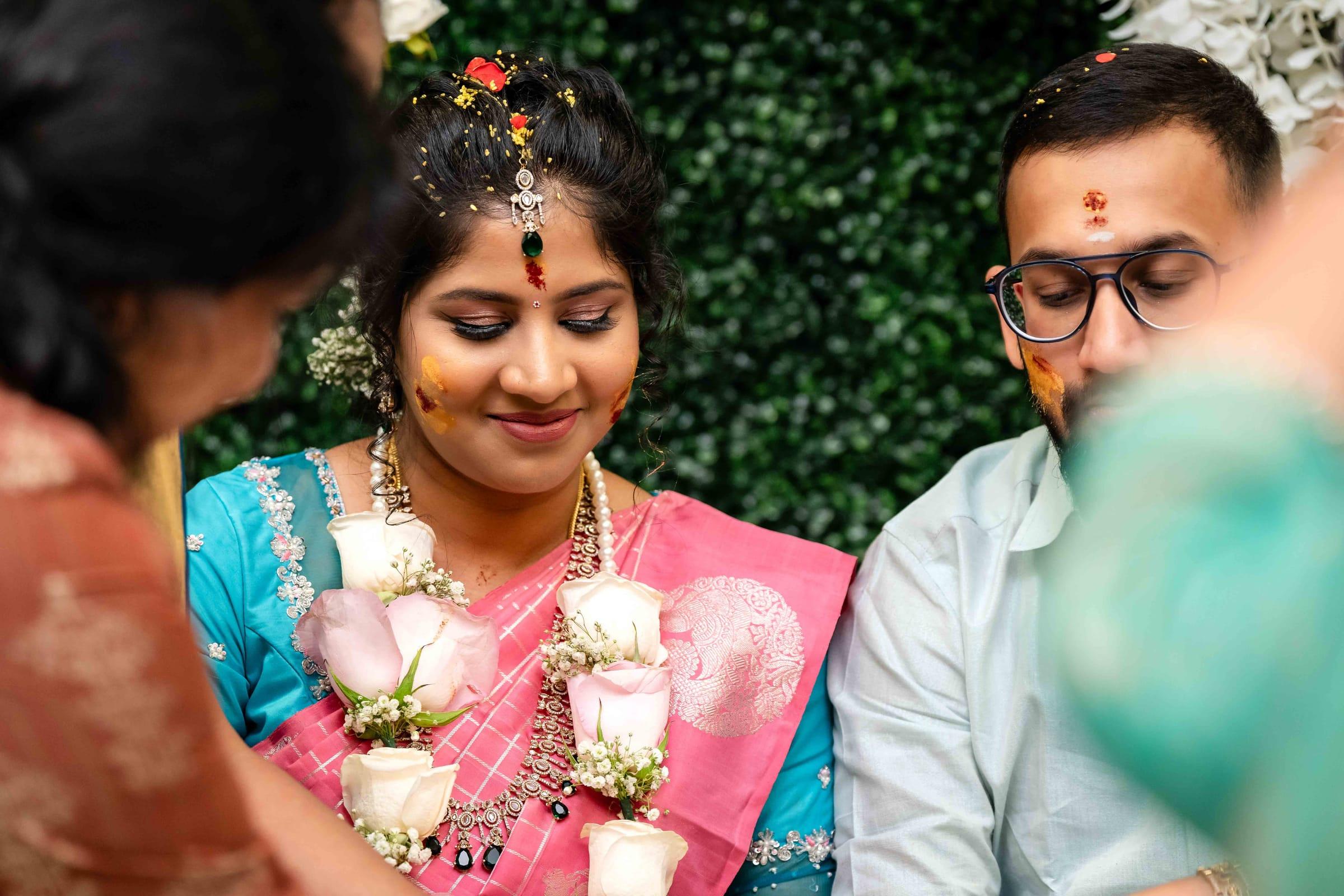 Mother-to-be blessed with garlands during a baby shower ceremony