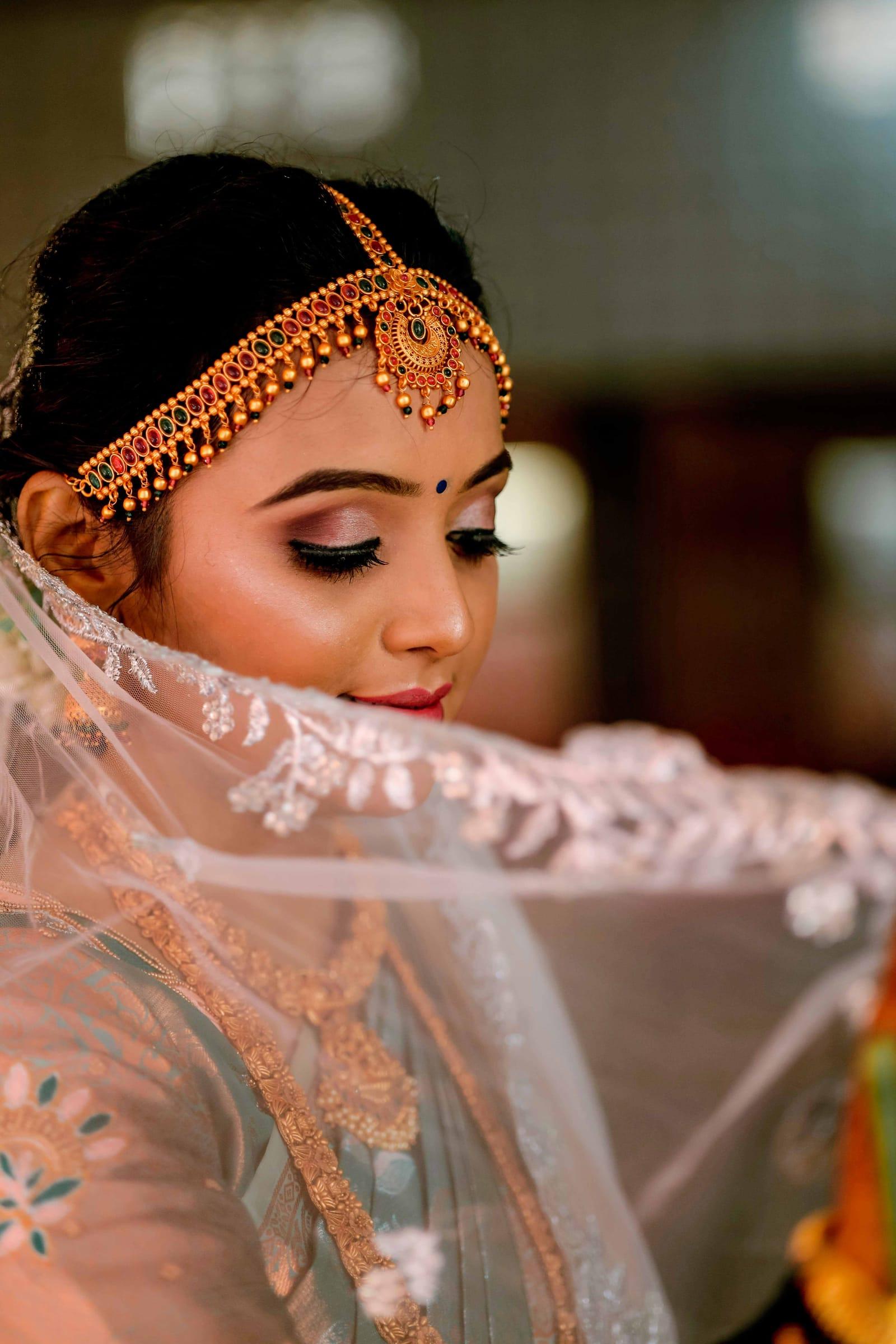 South Asian bride with maang tikka and veil, bridal portrait