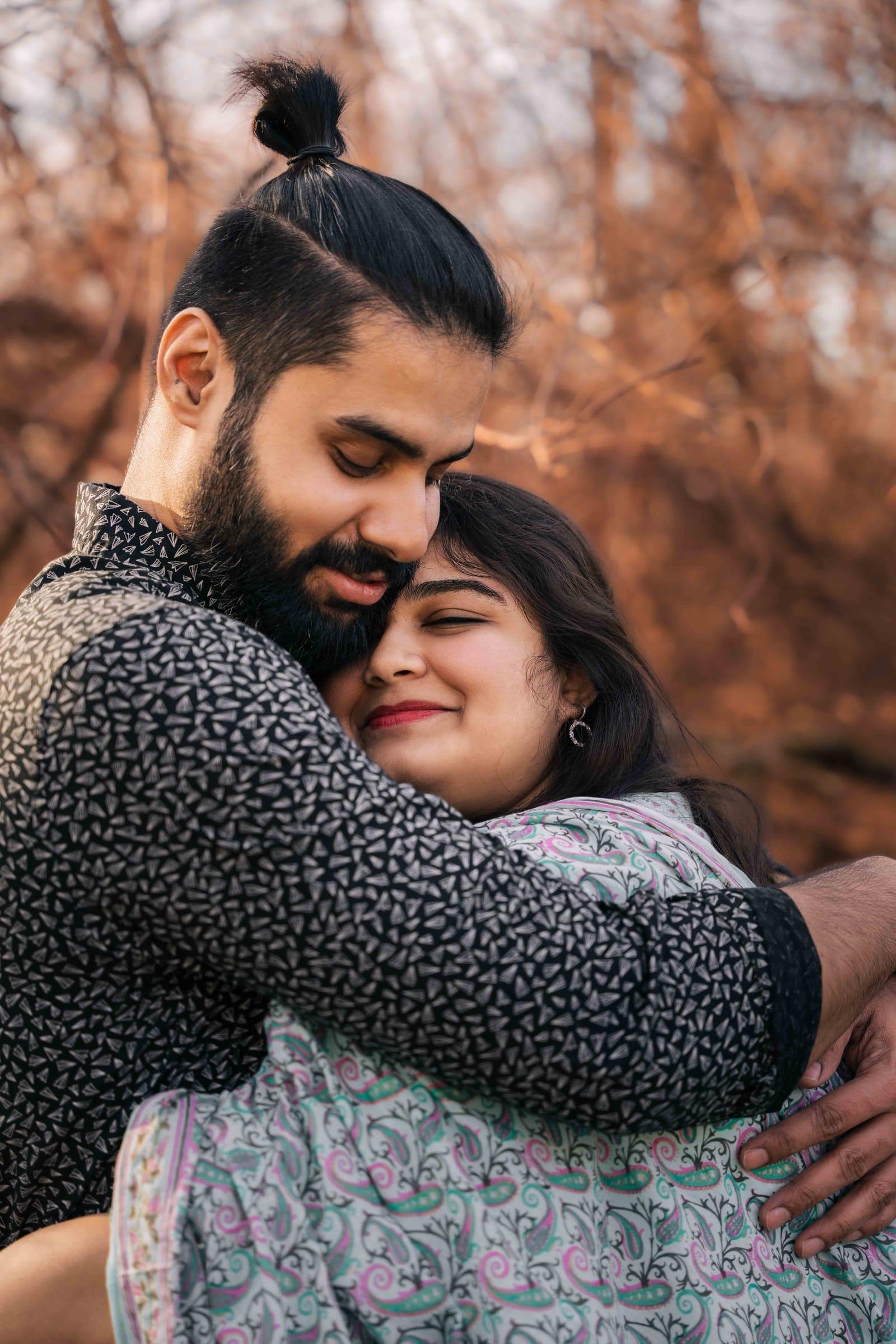 Couple embrace in warm autumn light during their pre-wedding shoot